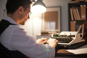 Young male prints article late at night