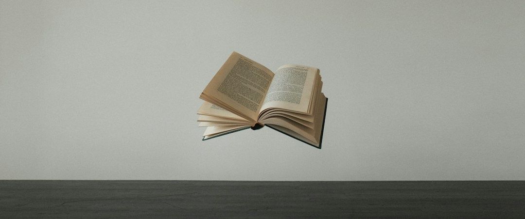 Aufgeschlagenes Buch schwebt über einer dunklen Tischfläche